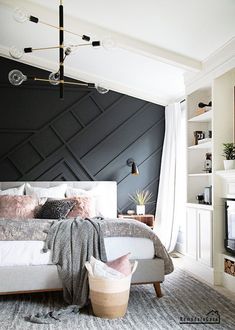 a bedroom with black walls and white bedding, pink pillows and throw blankets on the bed