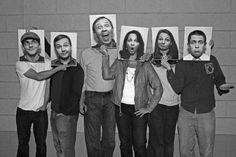 a group of people standing next to each other with pictures on their heads and hands