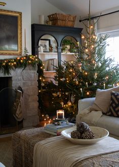 a living room filled with furniture and a christmas tree in front of a fire place