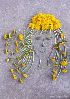 a woman's face made out of flowers on the ground with her eyes closed