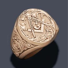 a gold signet ring with an image of the masonic symbol on it's center