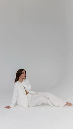 a woman sitting on the ground in white clothing