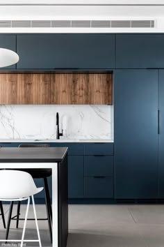 a modern kitchen with blue cabinets and marble counter tops