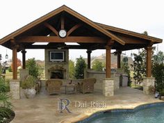 an outdoor living area next to a pool with a television and grill in the middle