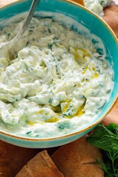 a blue bowl filled with cream cheese and herbs