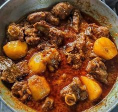 a pot filled with meat and potatoes on top of a stove