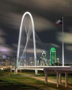 a very tall white bridge over a river with a lot of lights on it's sides