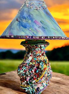 a lamp that is sitting on top of a piece of wood with beads all over it