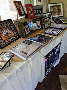 a table topped with framed pictures and photos on it's sides, along with other items