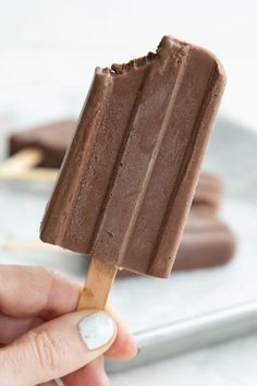 a hand holding an ice cream bar on a stick