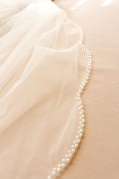 a wedding dress with a white beaded necklace