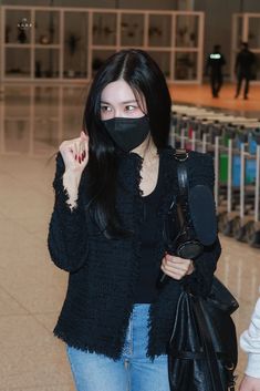 a woman wearing a face mask and holding a black bag