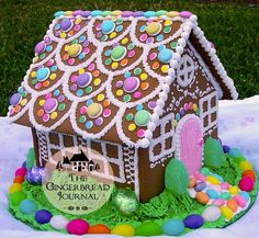 a gingerbread house is decorated with candy and candies on the grass in front of it