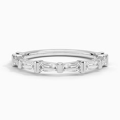 a white gold wedding band with baguetts and diamonds on the side, set in 18k white gold