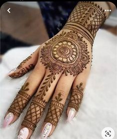 a woman's hand with henna tattoos on it