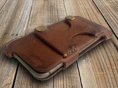 a brown leather case sitting on top of a wooden floor