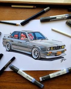 a drawing of a car on paper with crayons next to it