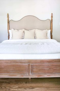 a large bed with white sheets and pillows