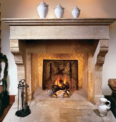 a fire place in the middle of a room with vases on top of it