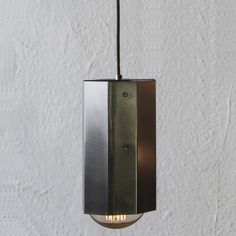 a light that is hanging from the ceiling in a room with white walls and flooring