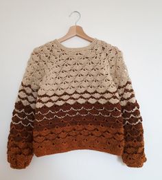 a brown and white sweater hanging on a hanger