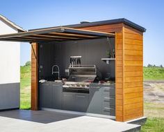 an outdoor kitchen is built into the side of a house with a grill and sink