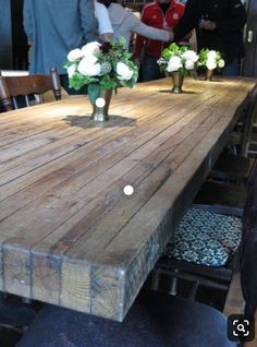 a wooden table with vases on top of it