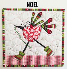 a close up of a quilt on a wall with the words noel written across it