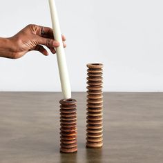 a stack of coins sitting on top of a wooden table next to a white stick