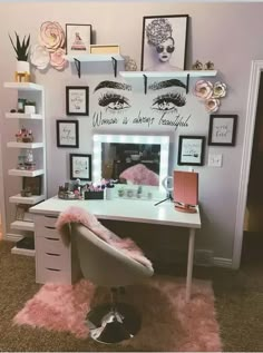 a white desk topped with a mirror and a pink chair next to a wall filled with pictures