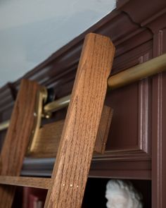 a close up of a wooden shelf in a room with bookshelves and shelves