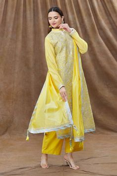 Yellow chanderi kurta with gota, leaf embroidery and mandarin collared neckline. Paired with palazzo, dupatta and potli bag.
Component: 4
Pattern: Embroidery
Type Of Work: Gota, leaf
Neckline: Mandarin collar
Sleeve Type: Full sleeves
Fabric: Chanderi
Color: Yellow
Other Details: 
Cutwork border
Contrast border
Tassel bordered dupatta
Occasion: Sangeet - Aza Fashions Collar Kurta, Kurta Palazzo Set, Potli Bag, Types Of Work, Palazzo Set, Potli Bags, Pattern Embroidery, Fashion App, Full Sleeves