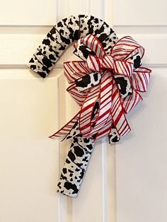 a dalmatian print bow hanging on the front door with red and white stripes