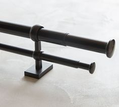 a pair of black metal rods on a white surface