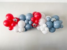 red, white and blue balloons are arranged on the wall