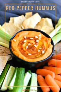 a bowl filled with hummus surrounded by carrots, celery and other vegetables