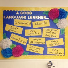 a bulletin board with words and pom poms on it that read a good language learner