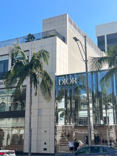 a car parked in front of a building with palm trees on the side of it