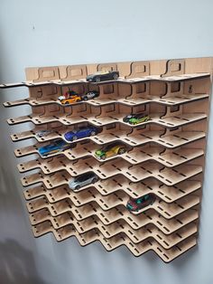 a wall mounted wooden rack with toy cars on it's sides and multiple shelves