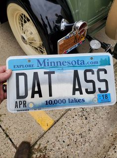 someone holding up a license plate for a car