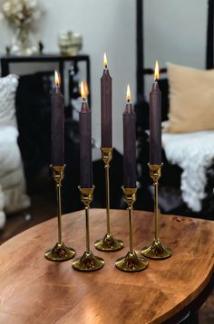 four candles are sitting on a table in the middle of a room