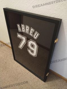 a black and white framed sign with the number 79 on it in front of a wall