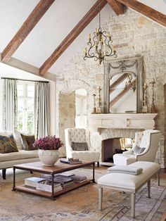 a living room filled with furniture and a fire place in front of a mirror on the wall