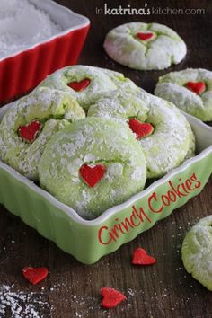 some heart shaped cookies in a green bowl and red hearts on the table next to it