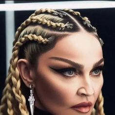 a woman with long braids and earrings on her head is looking at the camera