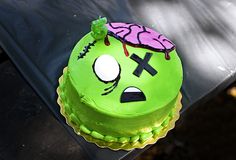 a green cake with a face and crossbones on it sitting on a table