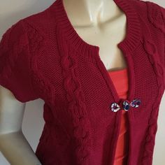 a mannequin wearing a red cardigan with buttons on the collar and sleeves