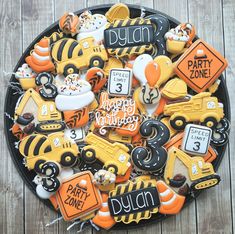 decorated cookies in the shape of school buses and construction vehicles are arranged on a plate