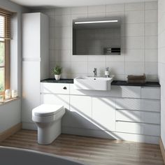 a bathroom with a toilet, sink and bathtub next to a window in it