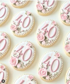 decorated cookies with pink and white frosting are arranged in the shape of numbers for an anniversary celebration